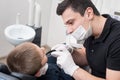 Pediatric dentist examining teeth of boy patient in dental clinic using dental tools - probe and mirror Royalty Free Stock Photo