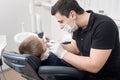 Pediatric dentist examining teeth of boy patient in dental clinic using dental tools - probe and mirror Royalty Free Stock Photo