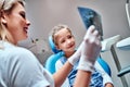 Pediatric dentist explaining to young patient the x-ray in dental clinic Royalty Free Stock Photo