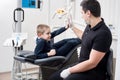 Pediatric dentist gives five young boy, congratulate patient for a successful treatment in dental office Royalty Free Stock Photo