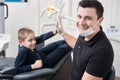 Pediatric dentist gives five young boy, congratulate patient for a successful treatment in dental office Royalty Free Stock Photo