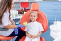 Pediatric dentist gives a little girl a big green apple. beautiful girl is smiling in dentist`s office. concept is a children`s Royalty Free Stock Photo