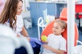 Pediatric dentist gives a little girl a big green apple. beautiful girl is smiling in dentist`s office. concept is a children`s Royalty Free Stock Photo