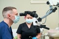 Pediatric dentist performing dental procedure assisted by nurse