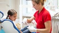 Portrait of pediatric dentist showing how to properly clean teeth Royalty Free Stock Photo