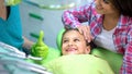 Pediatric dentist showing thumbs-up to little patient after regular checkup Royalty Free Stock Photo