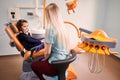 Pediatric dentist talking with little girl in dental office.