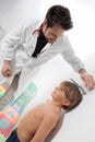 A pediatric doctor controlling the height of the little boy