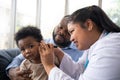 Pediatric doctor examining ear for a hearing test examining cute little girl in medical healthcare hospital or clinic. Smiling Royalty Free Stock Photo