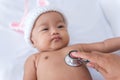 Pediatric doctor exams newborn baby girl with stethoscope in hospital Royalty Free Stock Photo