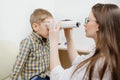 Pediatric Doctor ophthalmologist checks vision of child boy. Concept selection of glasses lenses.