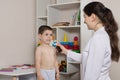 A pediatrician and a boy 3-4 years old. Nasal spray, rhinitis treatment, runny nose.