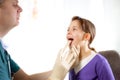 Pediatrician checking little girl throat