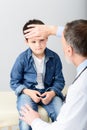 Pediatrician checking temperature of sick patient