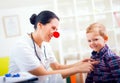 Pediatrician with clown nose and happy child patient