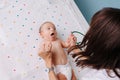 Pediatrician doctor checks the baby`s grasping reflexes Royalty Free Stock Photo