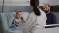 Pediatrician doctor discussing sickness treatment with sick patient and father Royalty Free Stock Photo