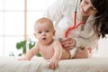 Pediatrician doctor examines baby with stethoscope checking heart beat. Royalty Free Stock Photo