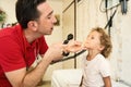 Pediatrician doctor examining child. Male doctor examining boy's ear with otoscope in hospital. Royalty Free Stock Photo