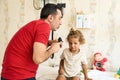 Pediatrician doctor examining child. Male doctor examining boy's ear with otoscope in hospital. Royalty Free Stock Photo