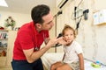 Pediatrician doctor examining child. Male doctor examining boy's ear with otoscope in hospital. Royalty Free Stock Photo