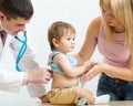 Pediatrician doctor examining child. Mother supporting kid. Royalty Free Stock Photo