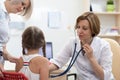 Pediatrician doctor examining kid patient with stethoscope Royalty Free Stock Photo