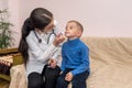 Pediatrician dropping nose to little patient in clinic