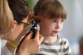Pediatrician examines ear of sick child in office Royalty Free Stock Photo