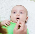 Pediatrician examines a newborn baby with a spatula