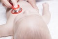 Pediatrician examines three months baby boy using a stethoscope Royalty Free Stock Photo