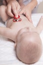 Pediatrician examines three months baby boy using a stethoscope Royalty Free Stock Photo