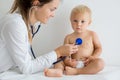 Pediatrician examining baby boy. Doctor using stethoscope to listen to kid Royalty Free Stock Photo