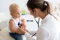 Pediatrician examining baby boy. Doctor using stethoscope to listen to kid