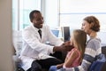 Pediatrician Examining Child In Hospital