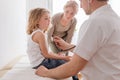 Pediatrician examining cute boy with pneumonia, worried mother behind them