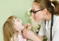 Pediatrician examining girl's throat