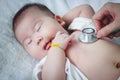 Pediatrician examining infant. Two months baby asian girl lying Royalty Free Stock Photo