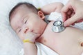 Pediatrician examining infant. Two months baby asian girl lying Royalty Free Stock Photo