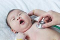 Pediatrician examining infant. Two months baby asian girl lying Royalty Free Stock Photo