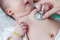 Pediatrician examining infant. Two months baby asian girl lying Royalty Free Stock Photo