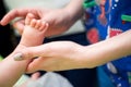 Pediatrician examining little baby in clinic. Closeup of a child& x27;s leg in doctor& x27;s hands. Royalty Free Stock Photo