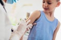 Pediatrician makes vaccination to small boy.