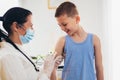 Pediatrician makes vaccination to small boy.