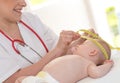 Pediatrician measuring head of baby