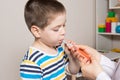 The pediatrician or nurse gives the child syrup in a measuring syringe. Treatment of cough, temperature in children