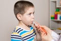 The pediatrician or nurse gives the child syrup in a measuring syringe. Treatment of cough, temperature in children