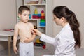 A pediatrician or nurse measures a child body temperature with a thermometer. Fever in children, colds.