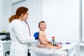 Pediatrician providing healthcare for her baby patient in the office of a specialized clinic for children. Neonatologist