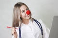 A pediatrician with a red nose